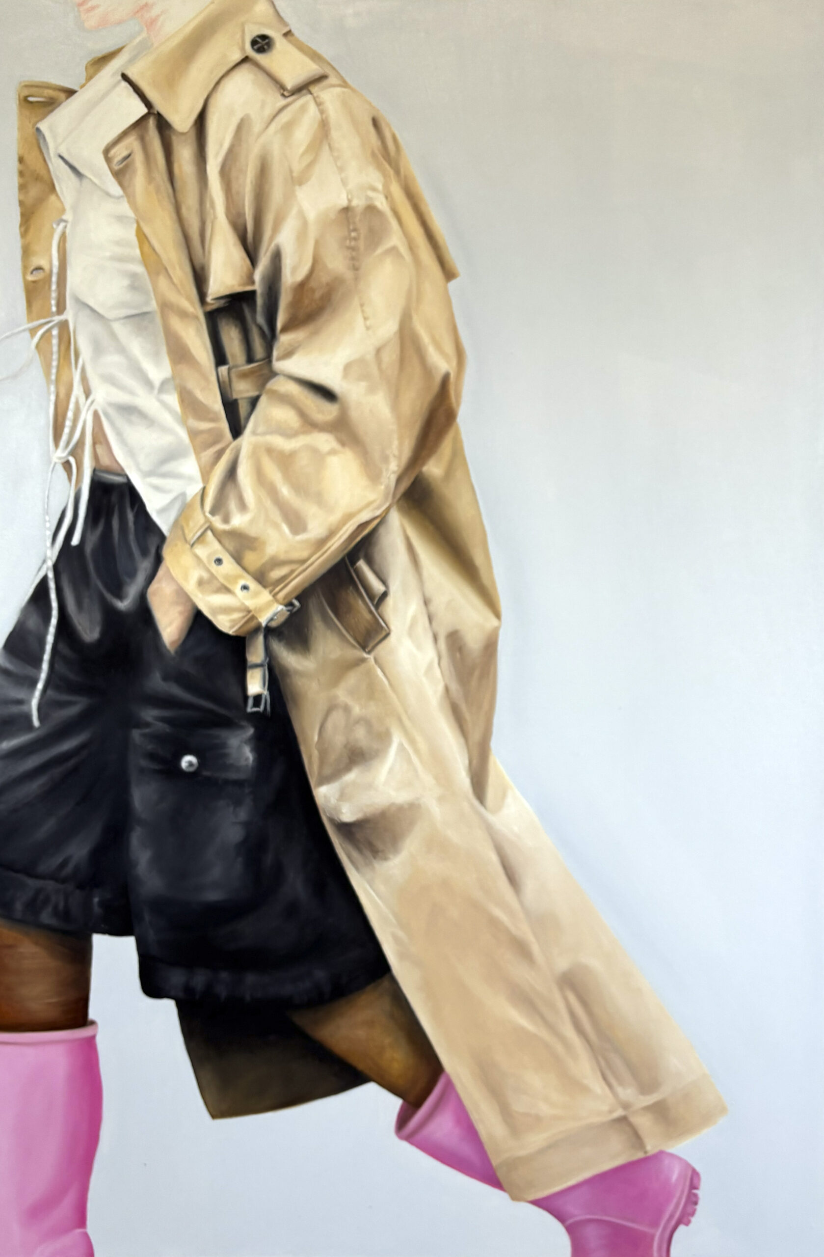 Henkilö beige takki, mustat shortsit, vaaleanpunaiset saappaat