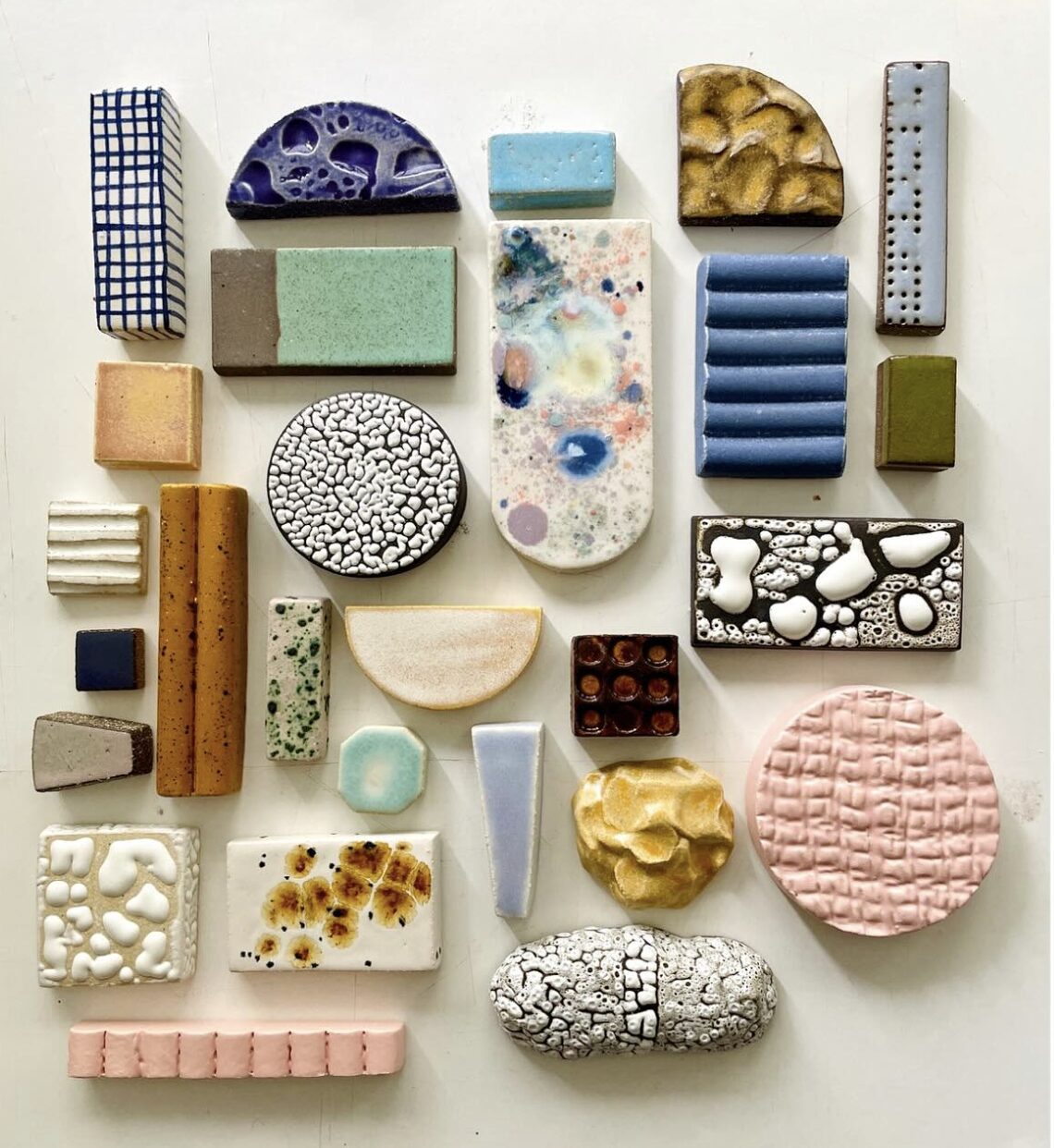 Erivärisiä ja -muotoisia laattoja pöydällä